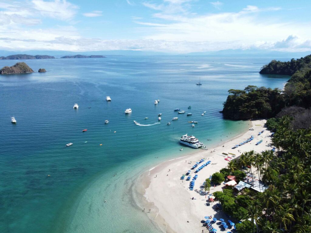 Tropical Costa Rica beach with golden sands, turquoise waters, and lush palm trees—top travel destination for surfing, eco-tourism, and relaxing beach vacations in 2025.